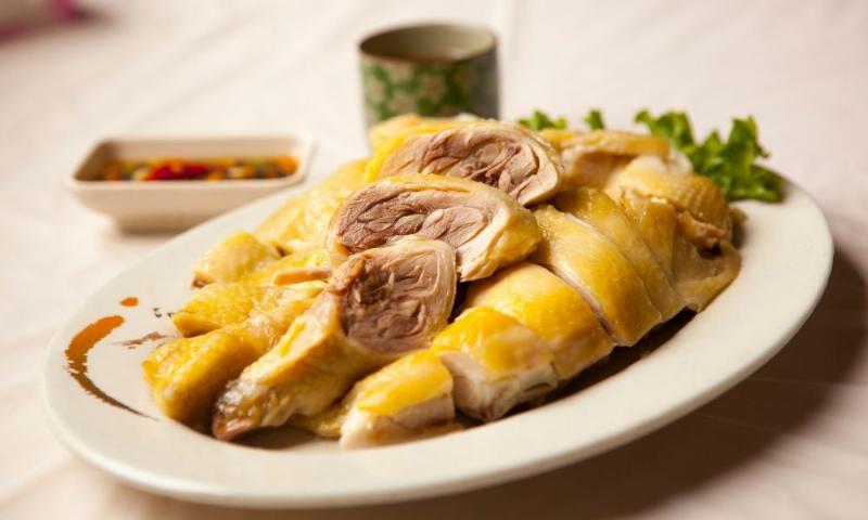 Nồi gà đang luộc trên bếp với nước dùng sôi nhẹ giúp thịt chín đều