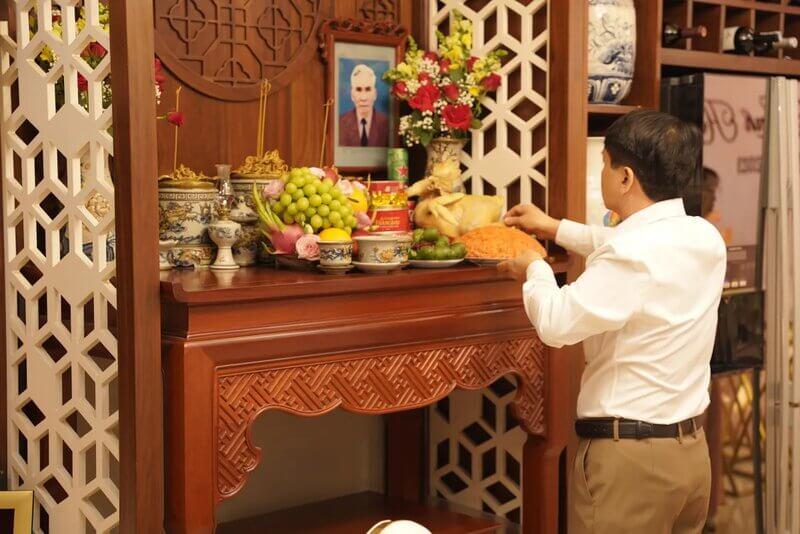 Người trẻ tuổi thắp hương trên bàn thờ gia tiên, thể hiện sự tiếp nối truyền thống tôn kính cửu huyền thất tổ trong xã hội hiện đại.