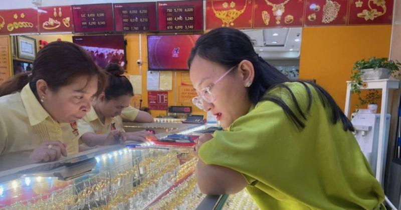 Hình ảnh người đang cầm miếng vàng SJC trên tay hoặc xếp chồng các miếng vàng SJC, thể hiện việc tích trữ hoặc đầu tư vàng vật chất.
