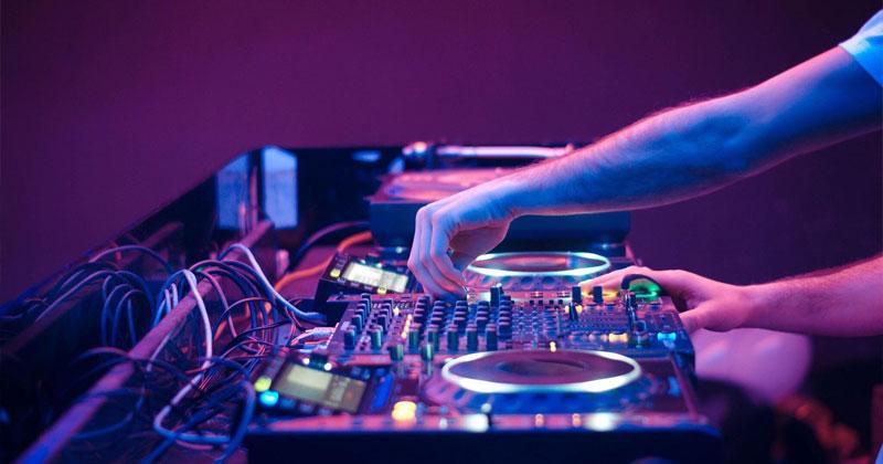 Hình ảnh DJ Tiên Moon làm việc trong phòng thu âm hoặc phòng luyện tập, thể hiện sự tập trung và chuyên nghiệp