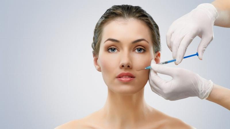 Hình ảnh một bàn làm việc có hộp đựng filler được mở ra, cho thấy tem mác và thông tin sản phẩm, tượng trưng cho việc kiểm tra filler chính hãng trước khi tiêm.